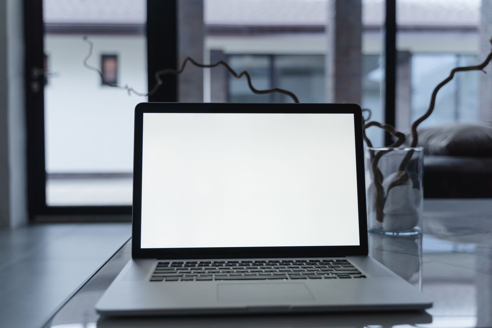 Notebook com tela em branco sobre mesa reflexiva, ideal para mockups e apresentações