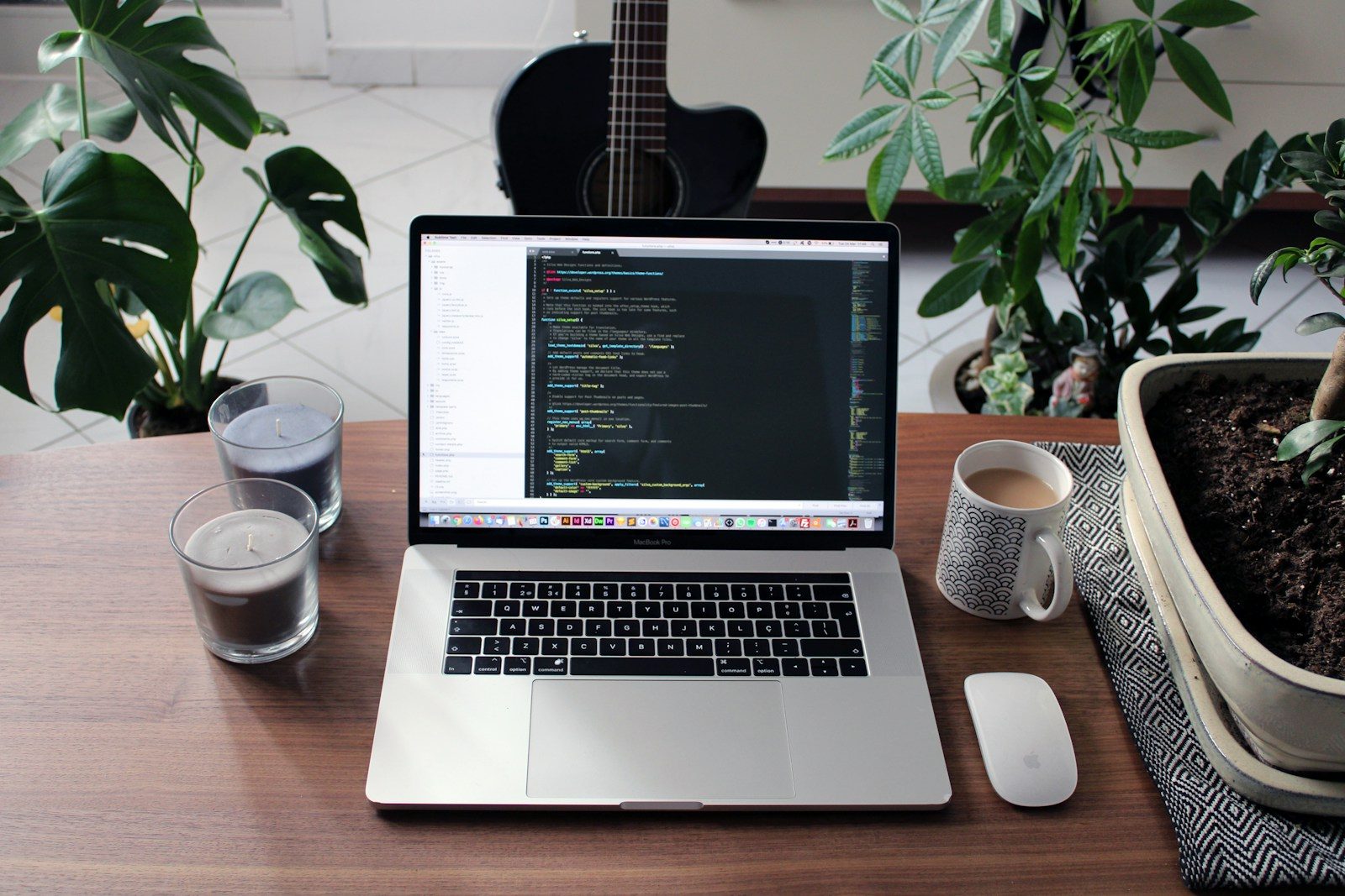 MacBook Pro ao lado de caneca de cerâmica branca em mesa de madeira marrom