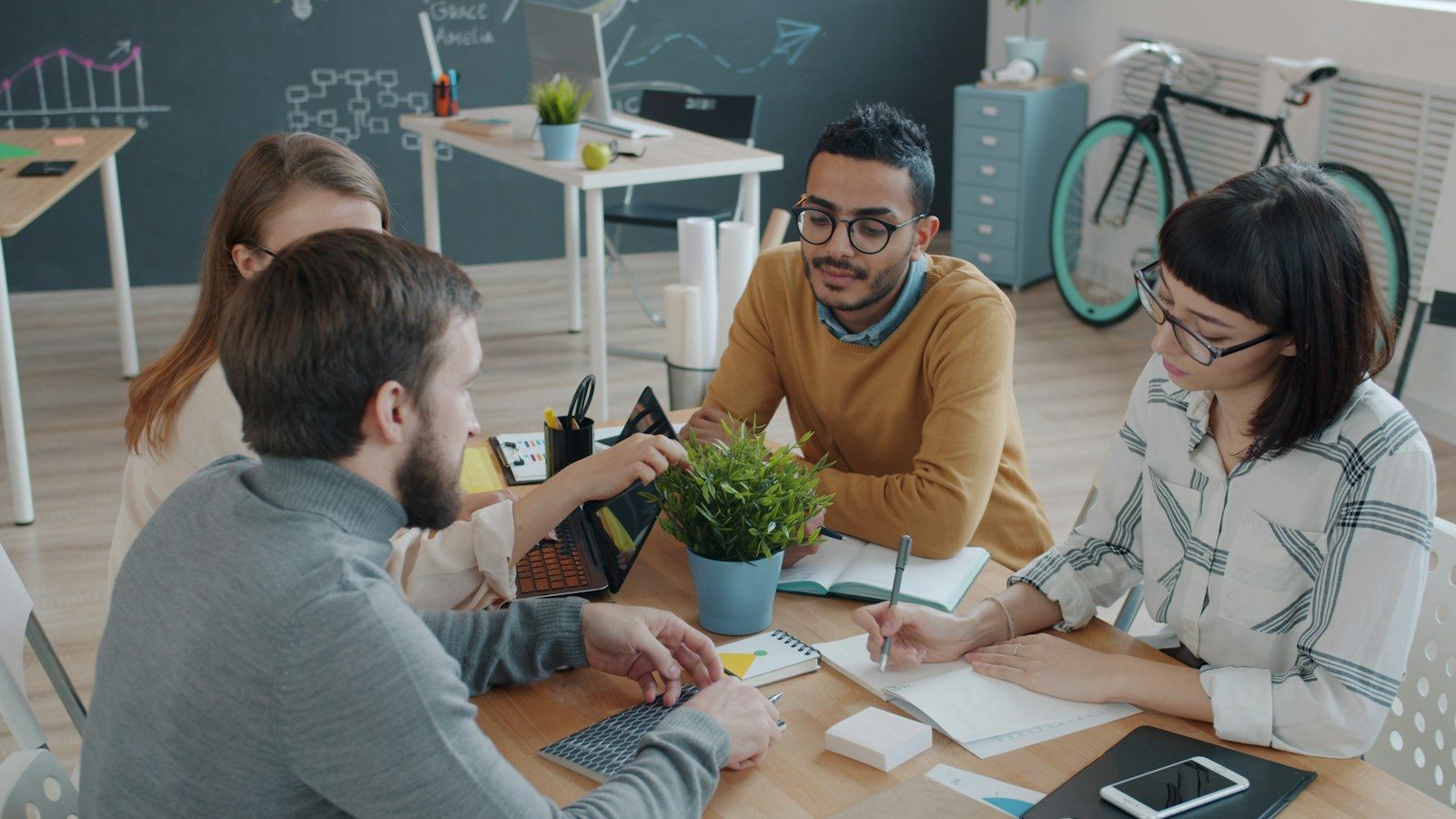 Equipe diversa colabora ao redor de uma mesa no escritório