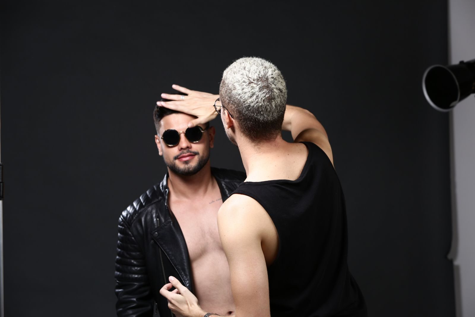 Modelo masculino de óculos escuros e jaqueta de couro na preparação de ensaio em Brasília