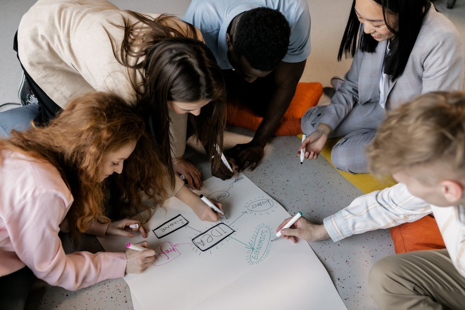 Equipe diversa de jovens colaborando em projeto de startup com esboços de brainstorming