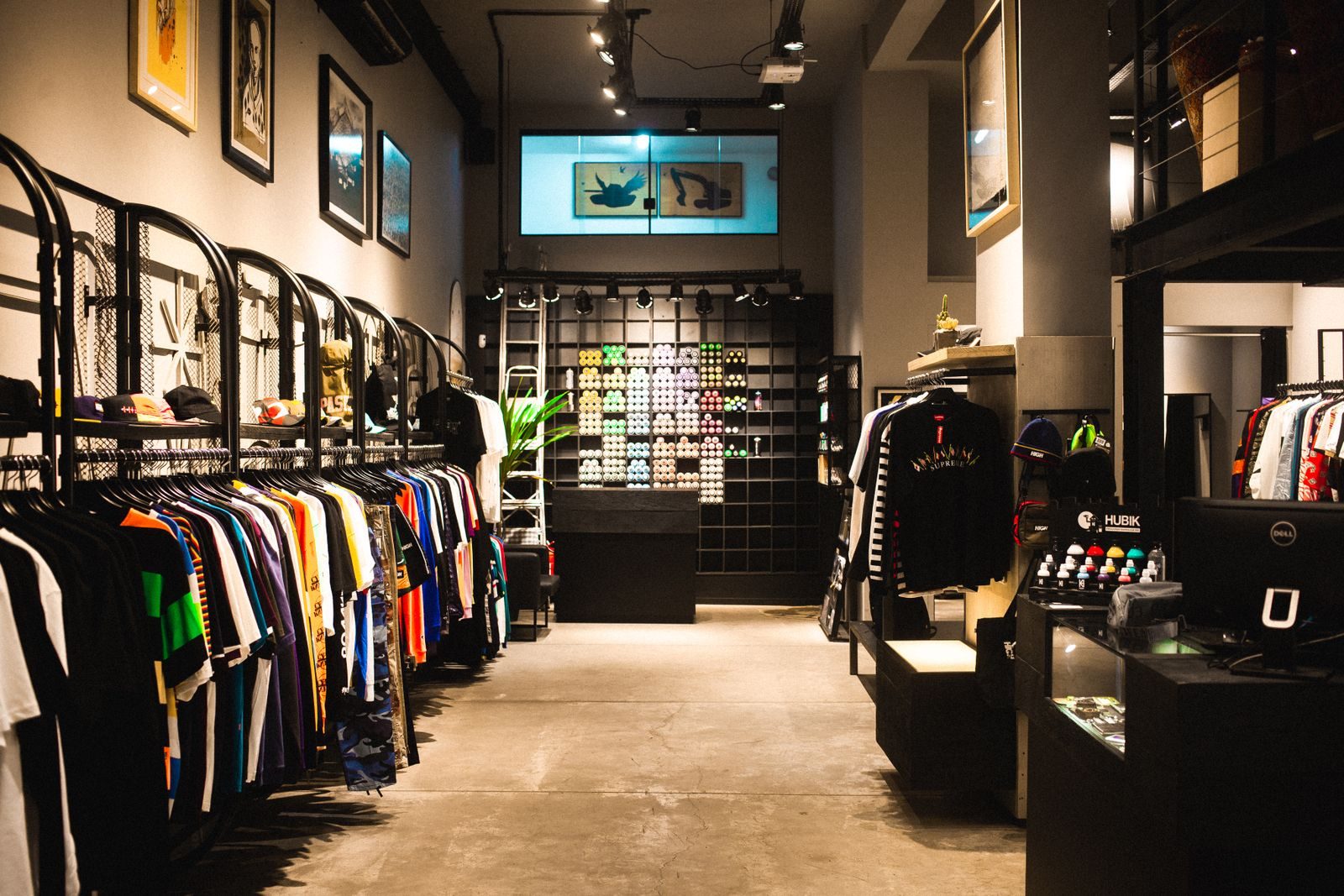 Interior de uma loja de moda urbana moderna com araras de roupas coloridas