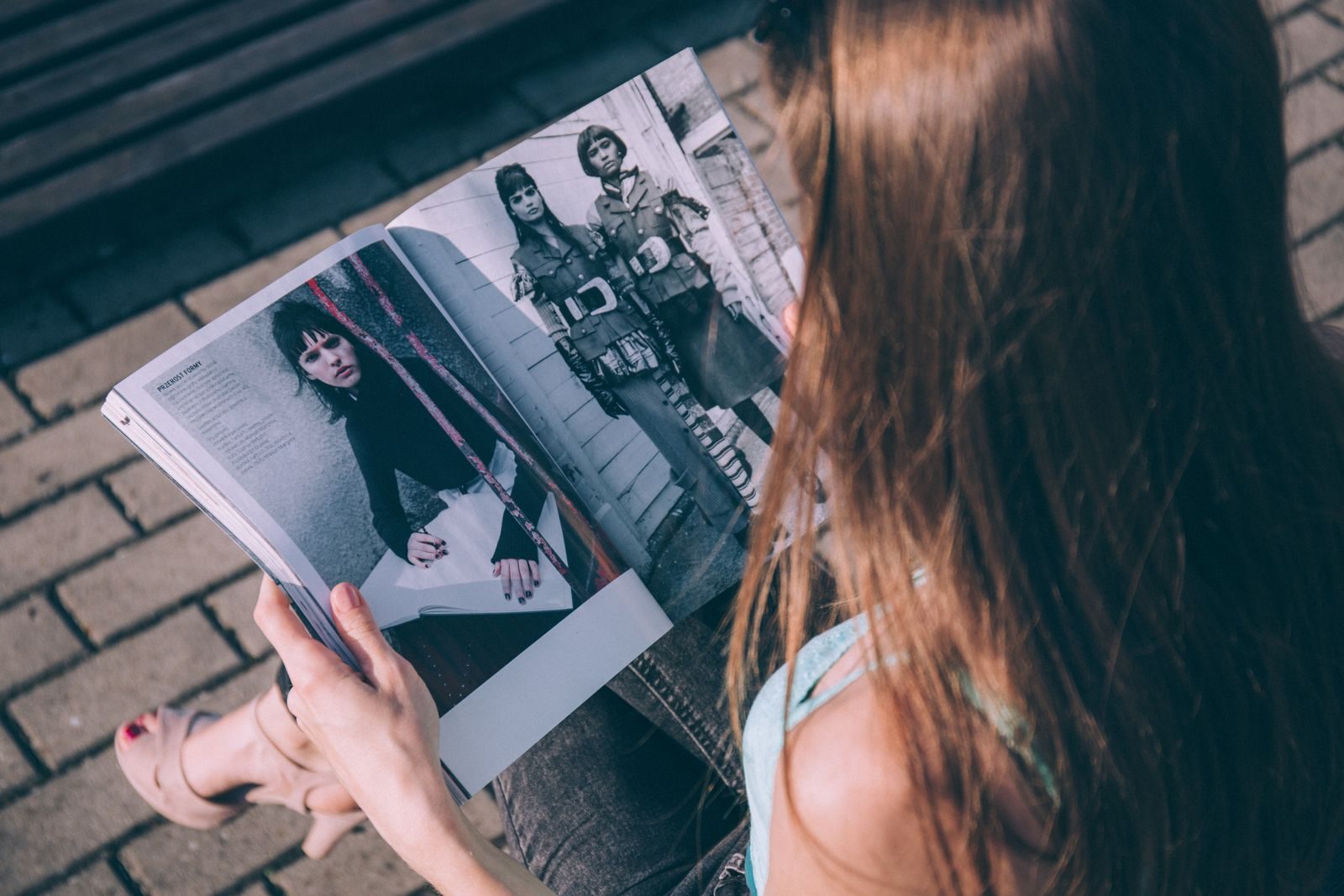 Mulher lendo uma revista de moda ao ar livre