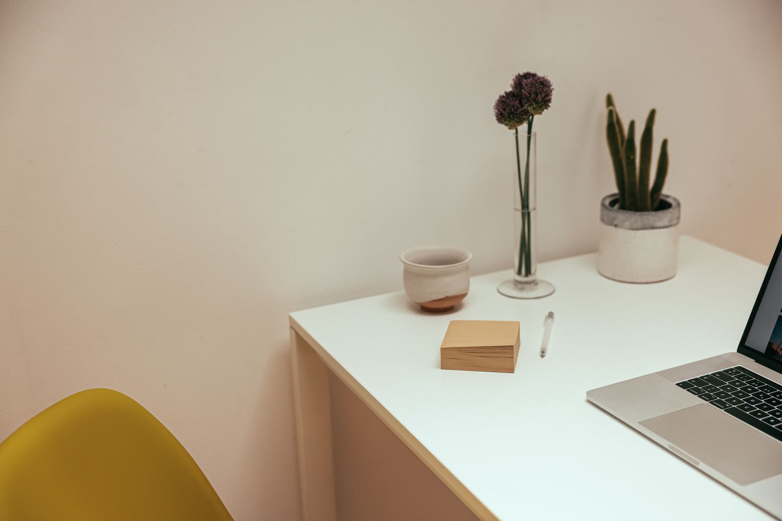 Mesa minimalista, limpa e moderna com notebook, plantas e uma xícara de cerâmica