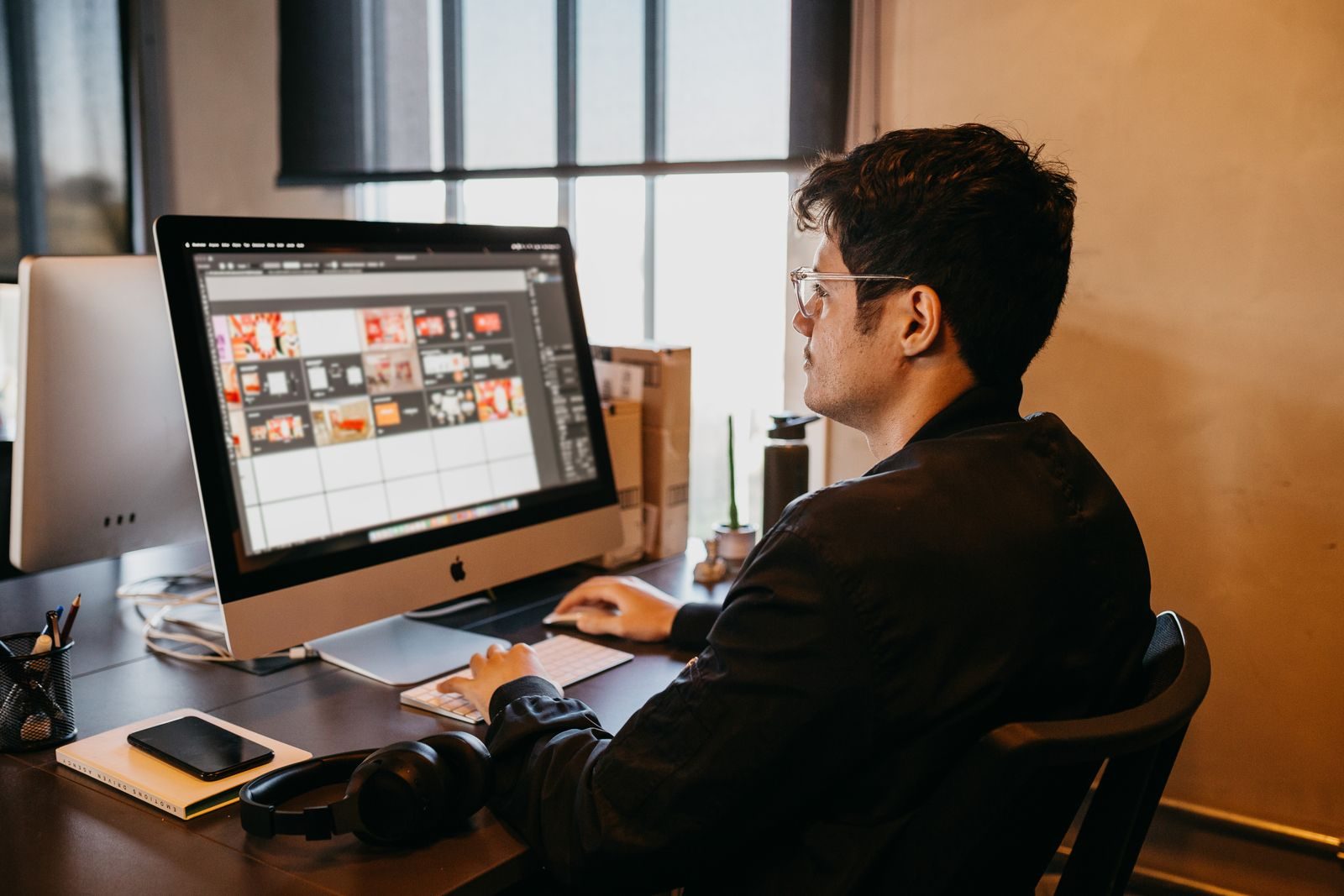 Homem fazendo design gráfico no computador em escritório moderno com luz natural