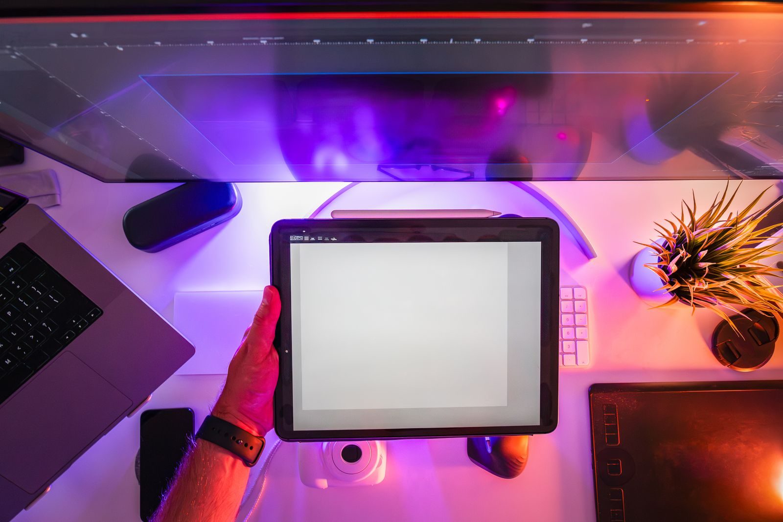 Espaço de trabalho vibrante com mesa digitalizadora e luz neon, ideal para designers ou fotógrafos