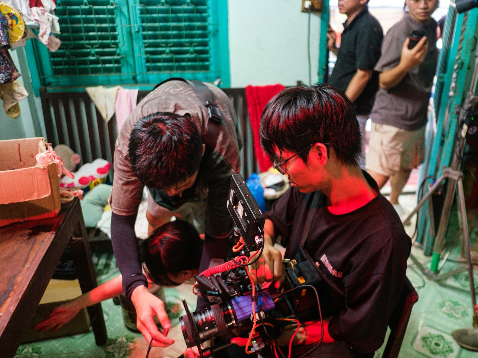 Cineastas ajustando com cuidado equipamento de câmera profissional em ambiente interno