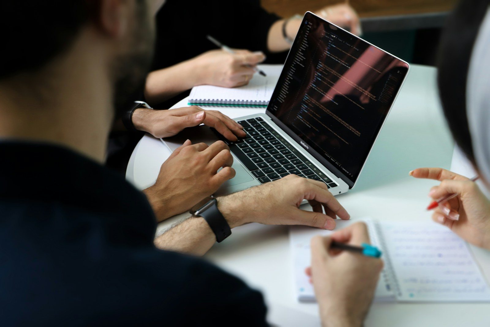 Grupo de pessoas sentadas em volta de um notebook
