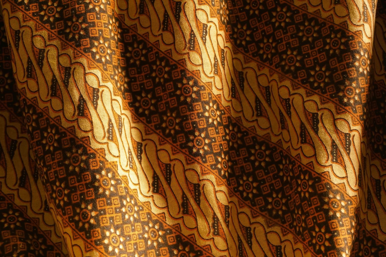 Close de tecido batik detalhado com padrões tradicionais e cores vibrantes