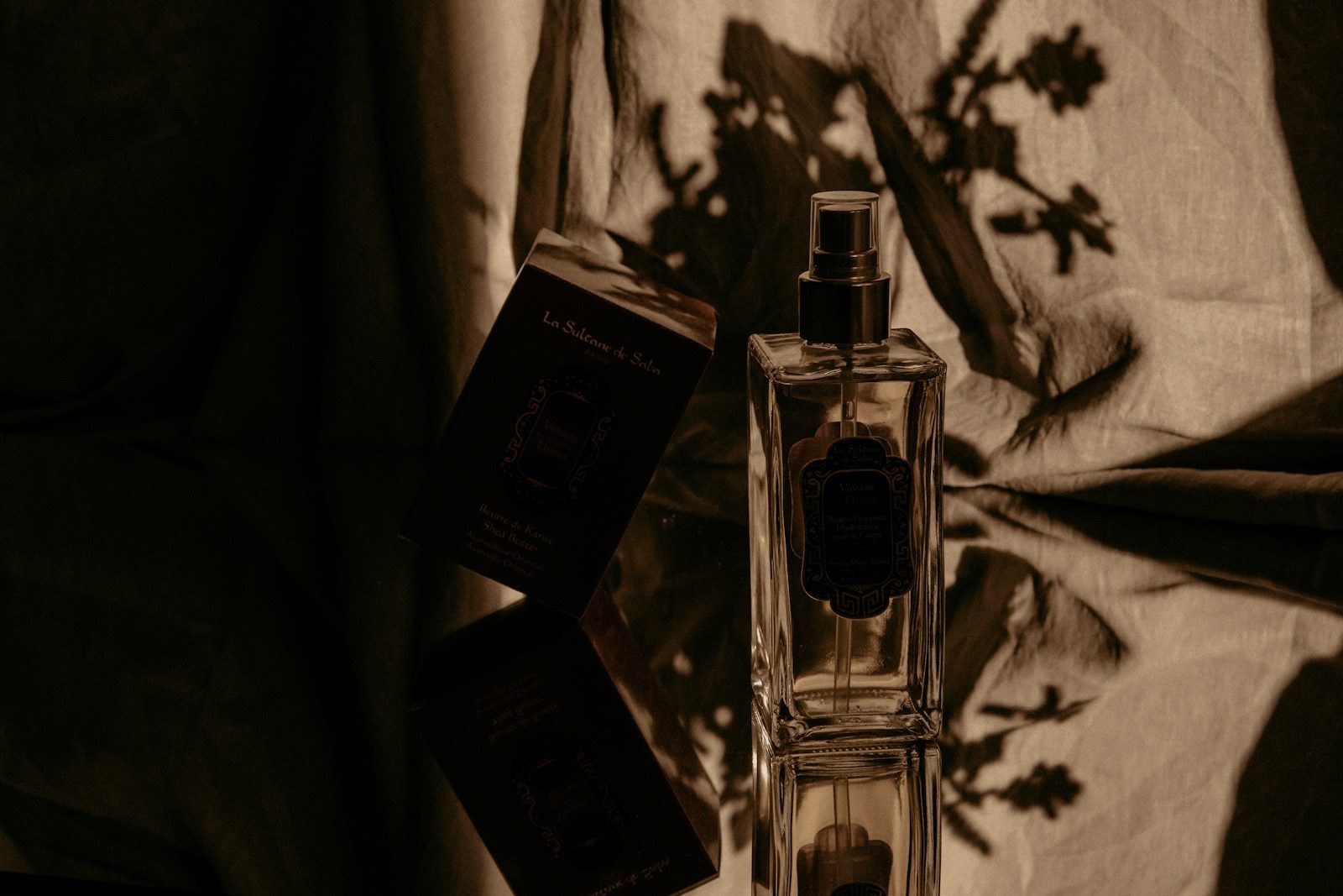 Frasco de perfume de vidro transparente sobre caixa preta