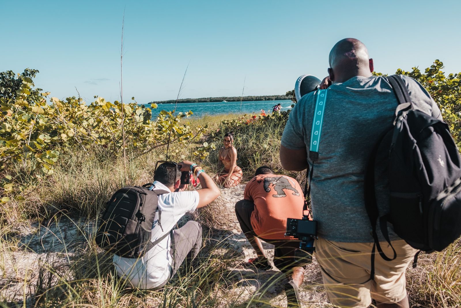 Bastidores de ensaio fotográfico na praia em Miami com fotógrafos e uma modelo