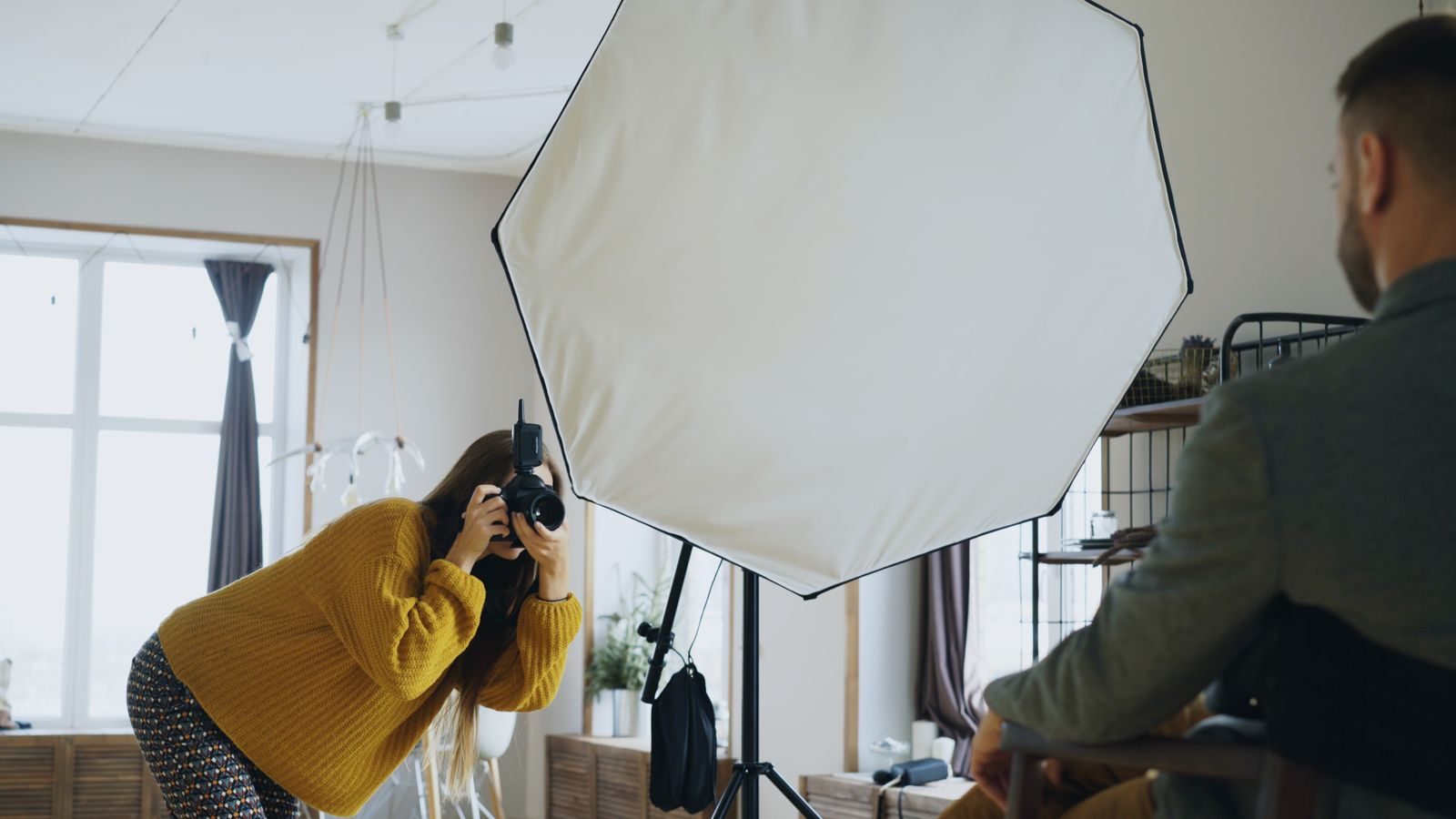 Fotógrafo fazendo retratos em estúdio interno moderno