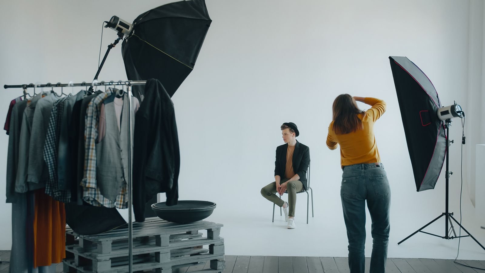 Ensaio de moda em estúdio moderno com fotógrafo, modelo e iluminação