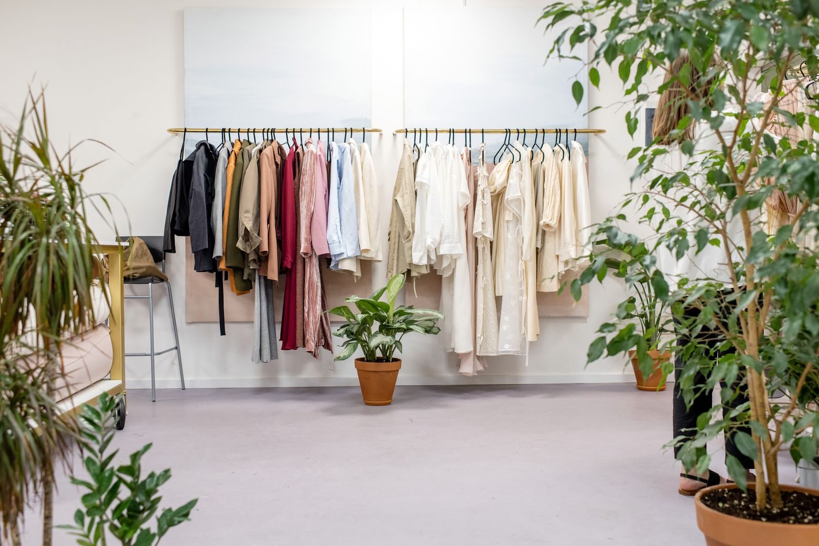 Boutique elegante com coleção de roupas vibrantes e plantas exuberantes
