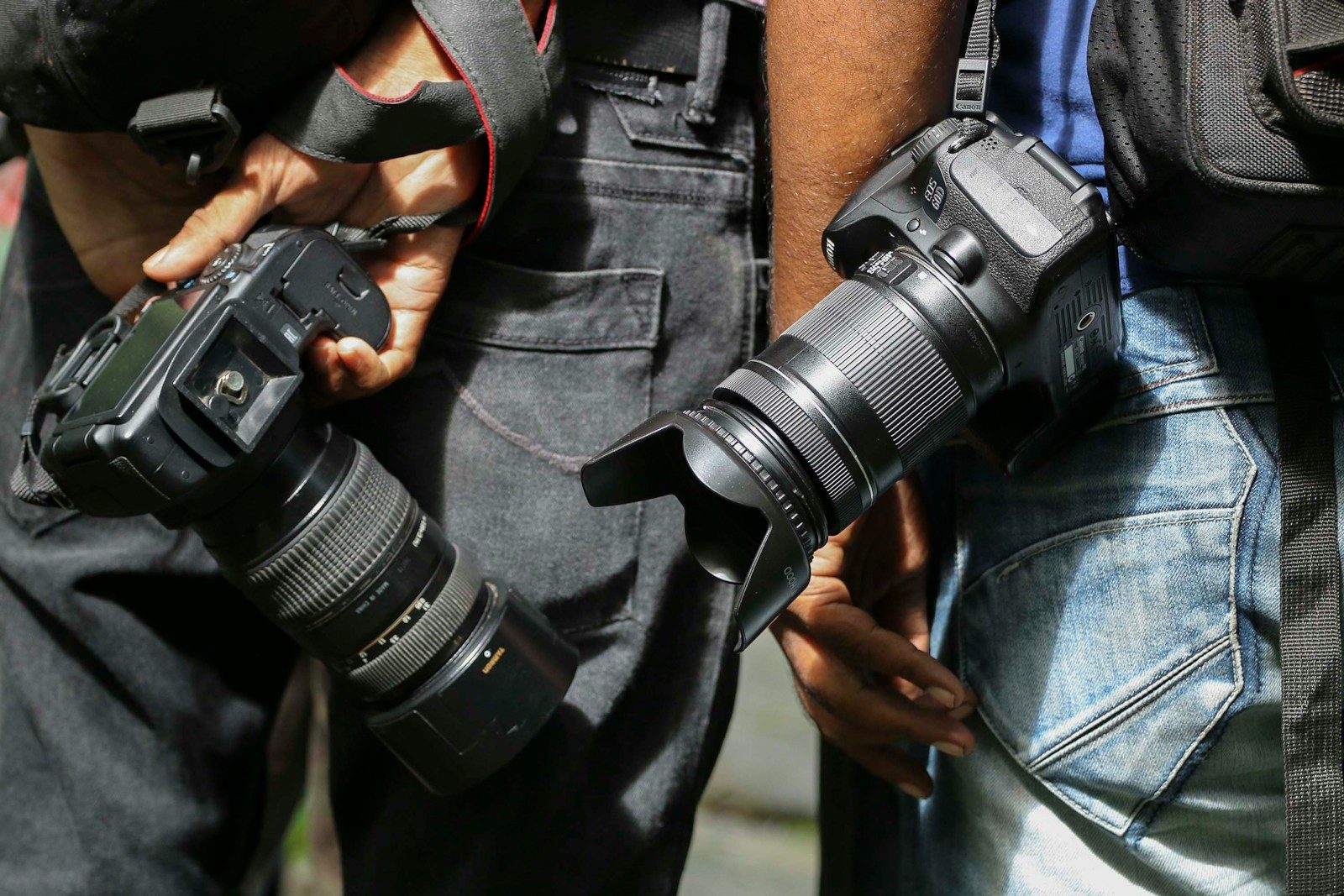 Pessoa de jaqueta preta segurando câmera DSLR preta