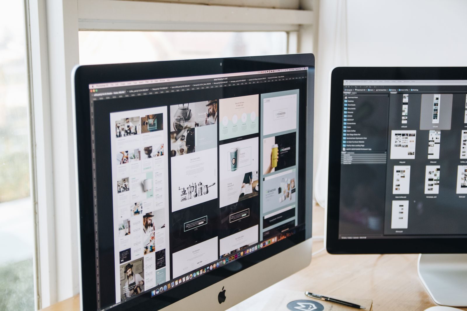 Mesa de escritório moderna com dois monitores exibindo software de design