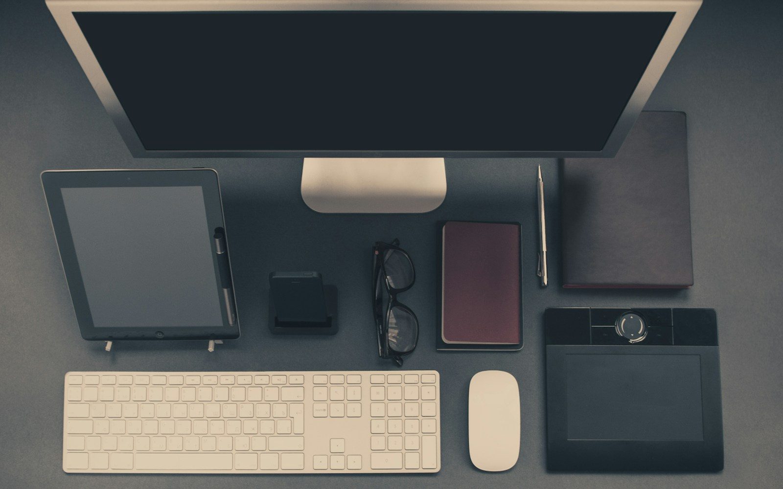 Computador cinza com tablet e óculos