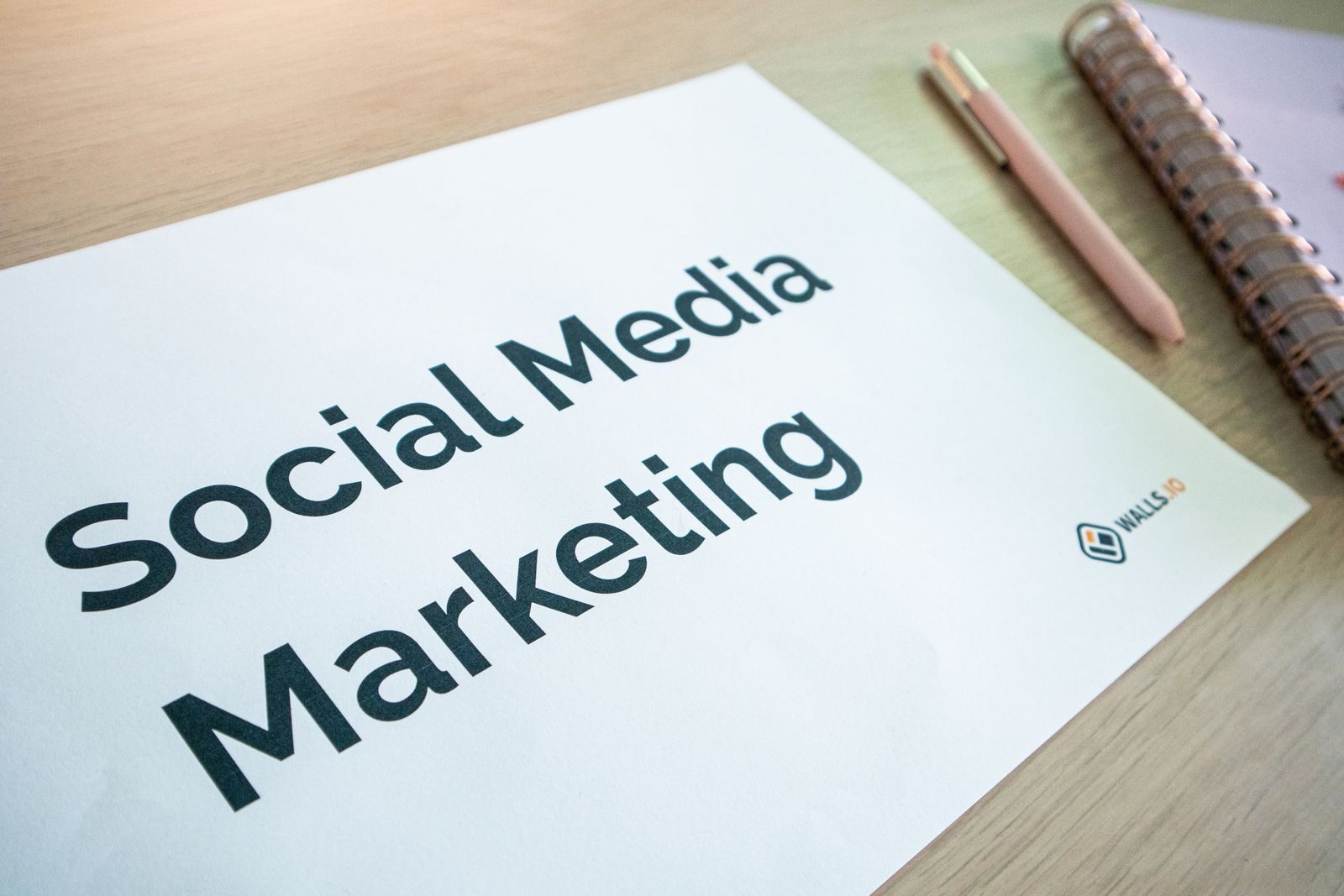 Close de documento de marketing em redes sociais sobre mesa com caneta e caderno