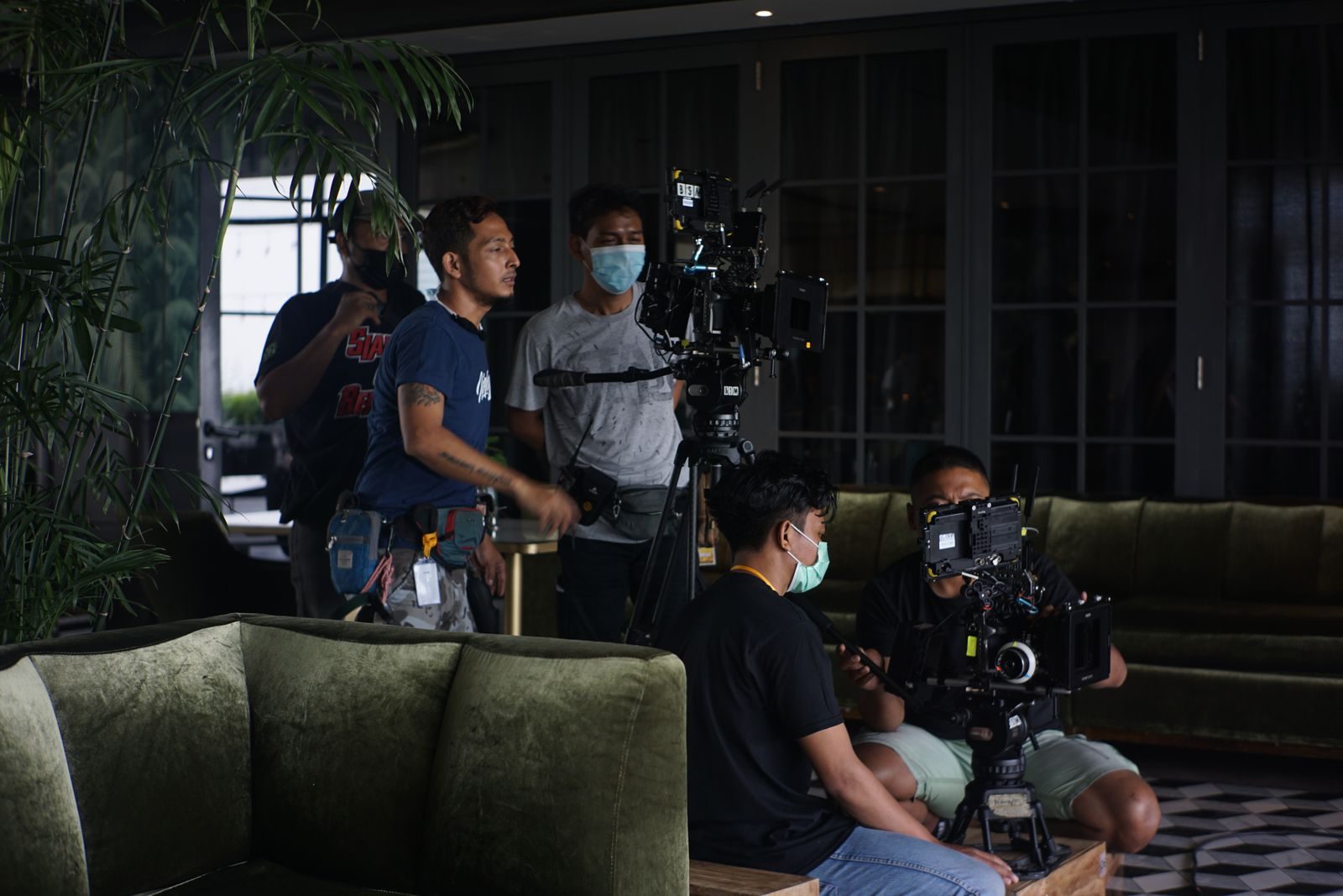 Equipe de filmagem montando equipamento de câmera para uma cena interna