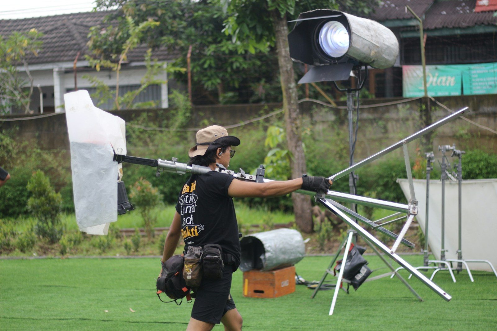 Membro da equipe carrega equipamento em um set