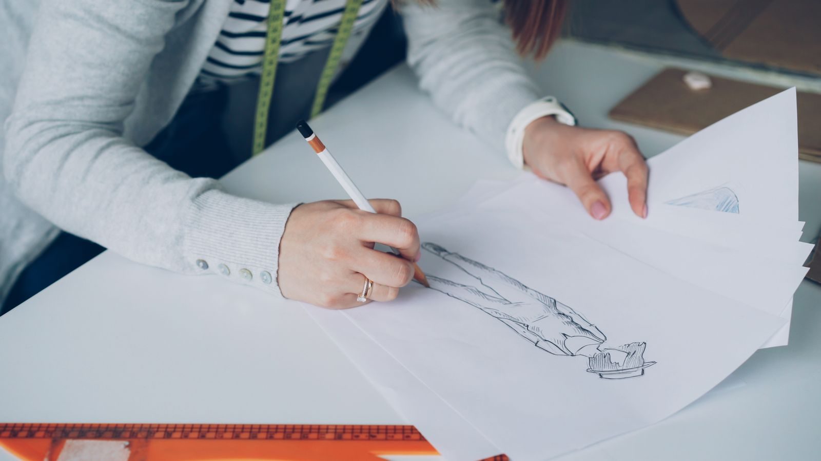 Estilista desenhando croquis no papel