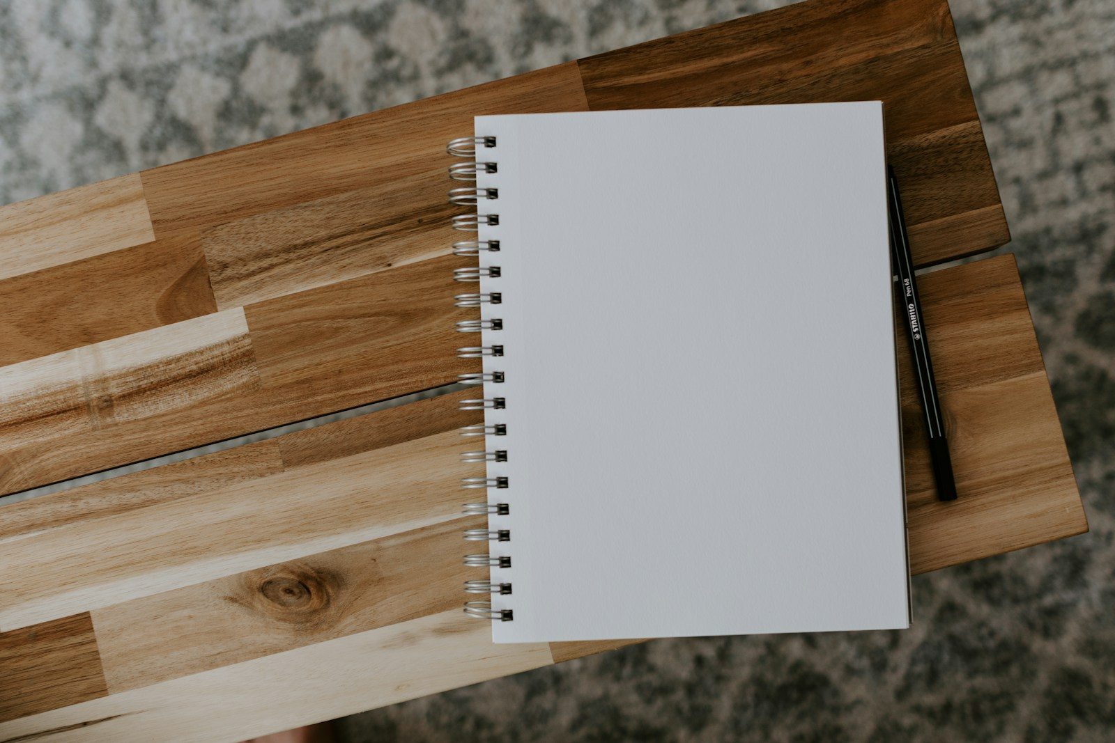 Caderno espiral branco sobre mesa de madeira marrom