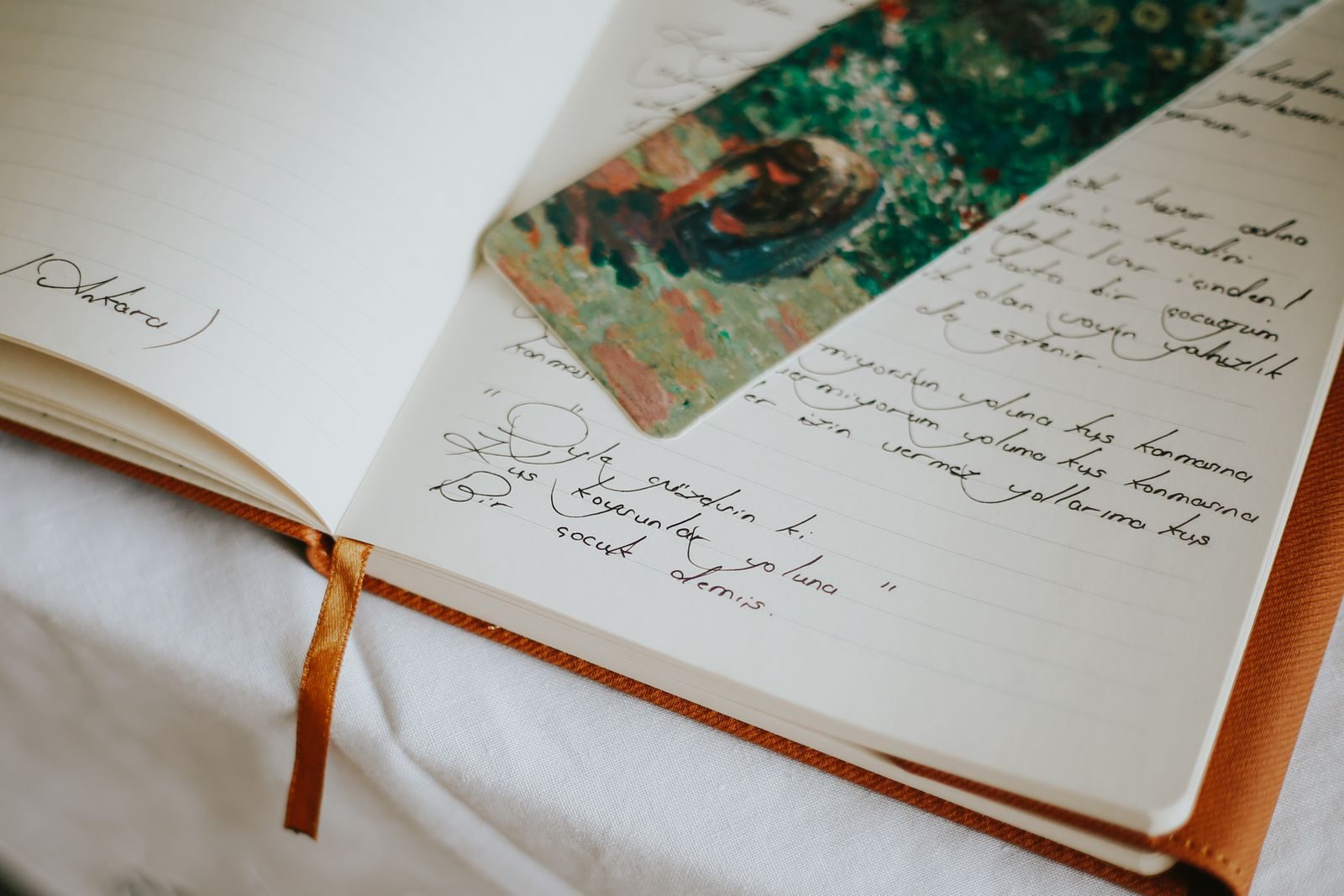 Close de um diário aberto com texto manuscrito e um marcador colorido, evocando criatividade