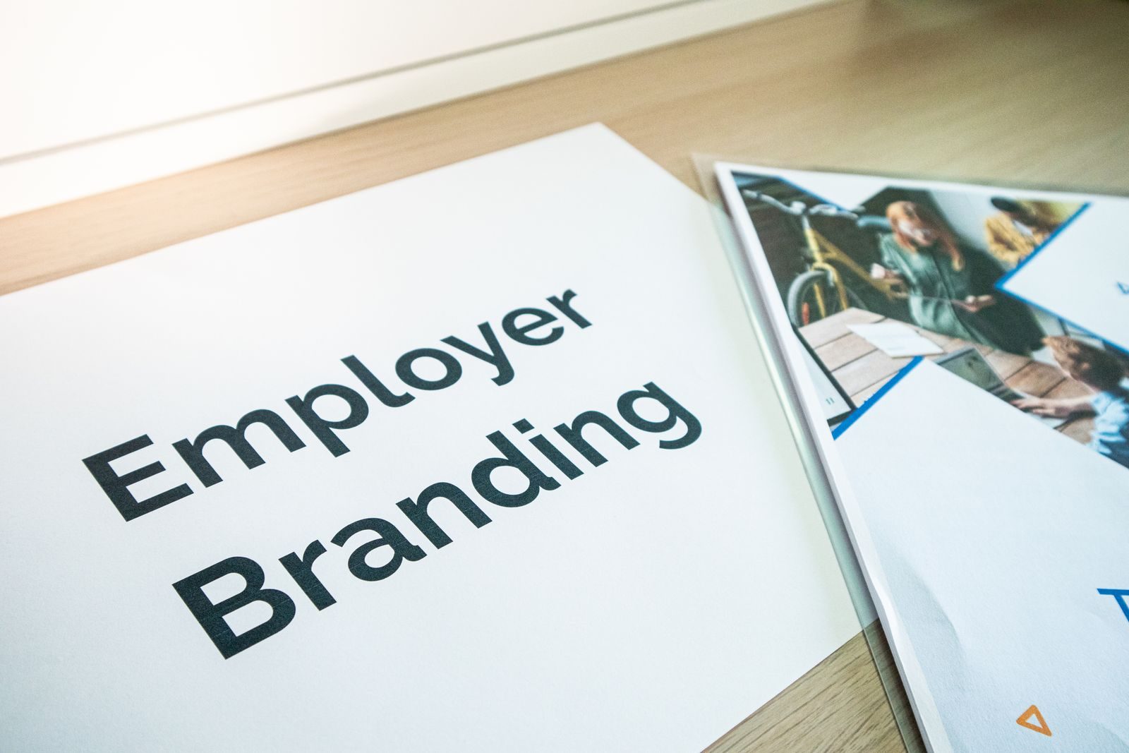 Documentos sobre employer branding em uma mesa de madeira, ideal para temas de negócios