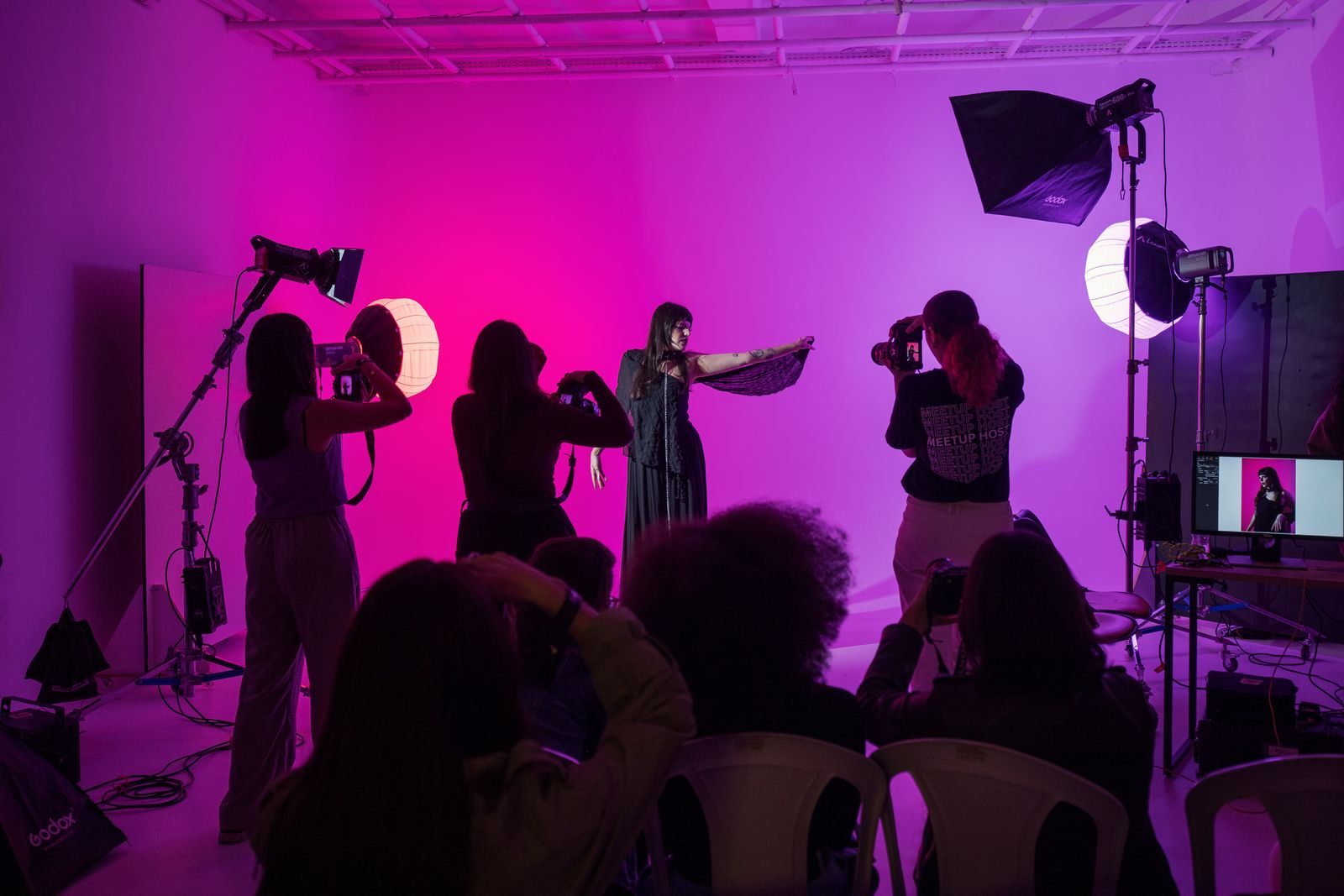 Workshop de fotografia ao vivo com iluminação vibrante e participantes ativos