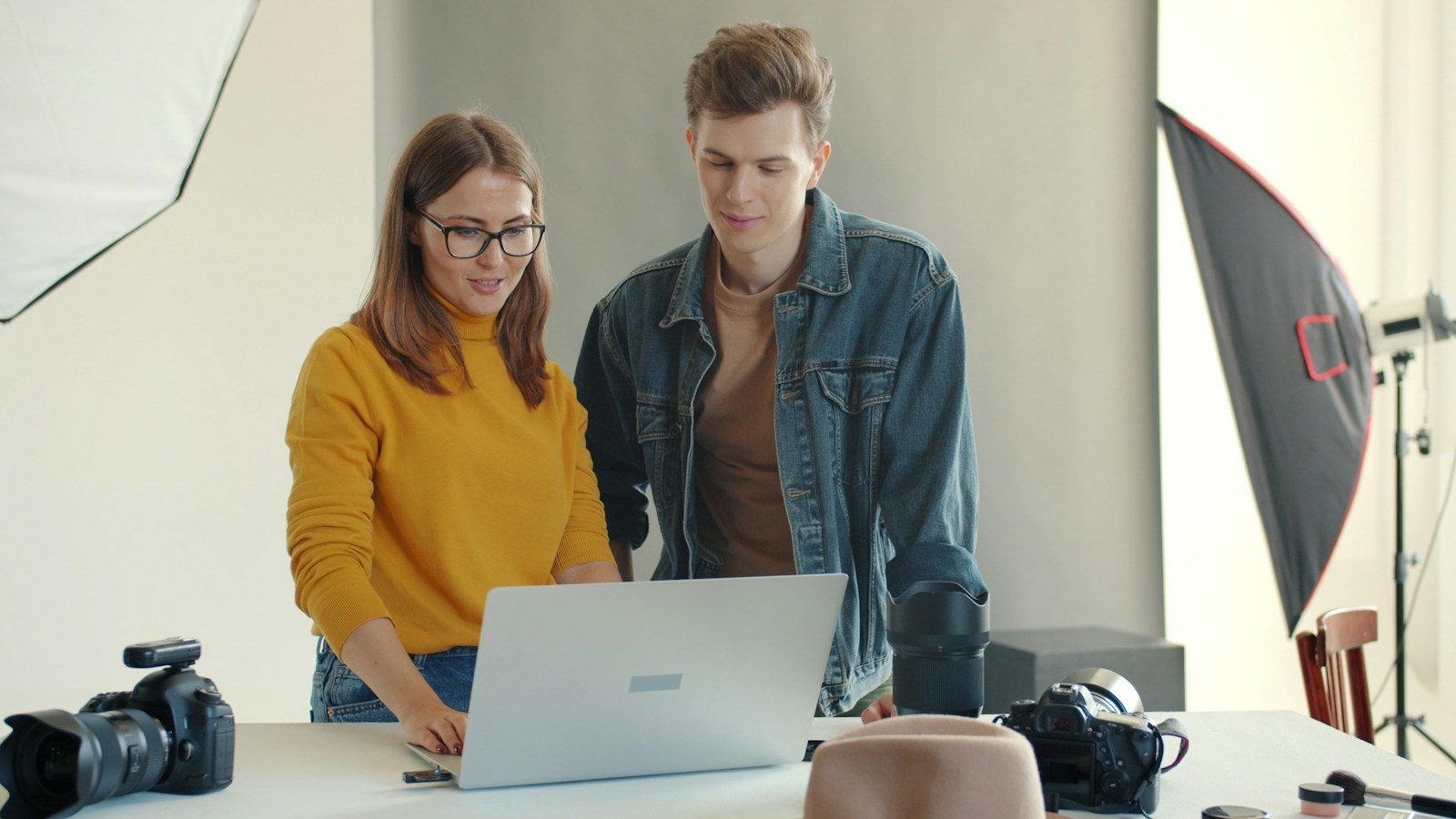Duas pessoas olhando para um notebook em um estúdio