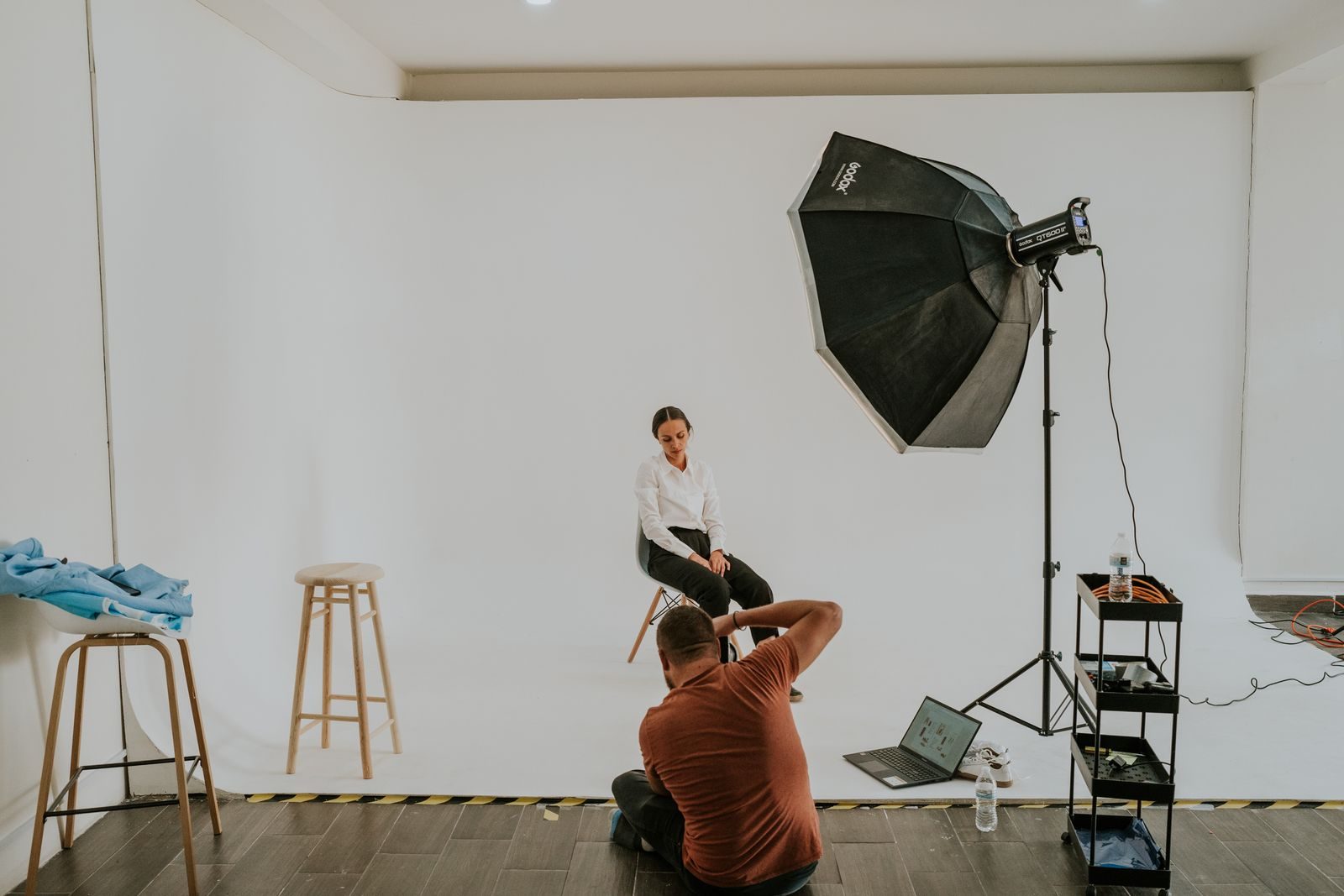Fotógrafo fotografando uma modelo em estúdio profissional com iluminação