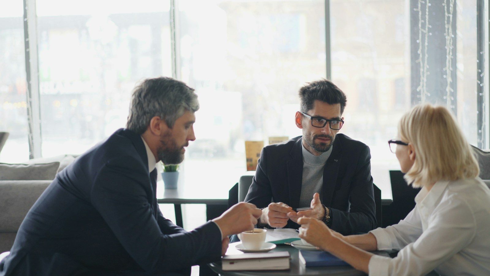 Grupo de pessoas sentadas em volta de uma mesa conversando
