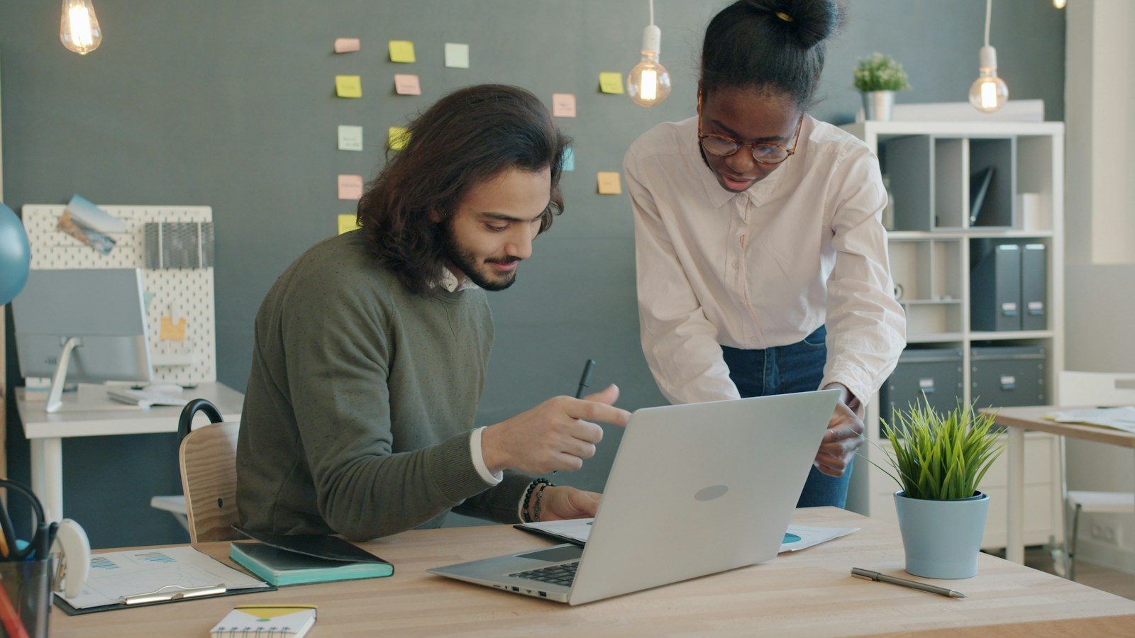 Dois colegas colaborando em um notebook em um escritório
