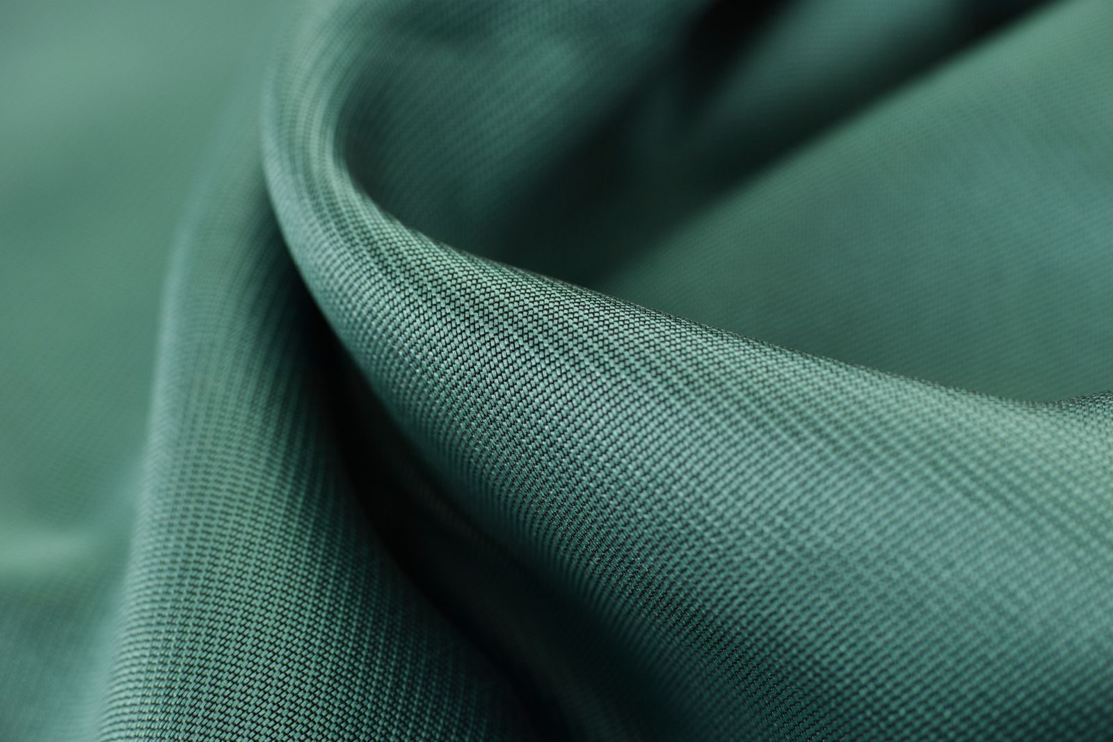 Close da textura de um tecido de cetim verde elegante, com superfície lisa e macia