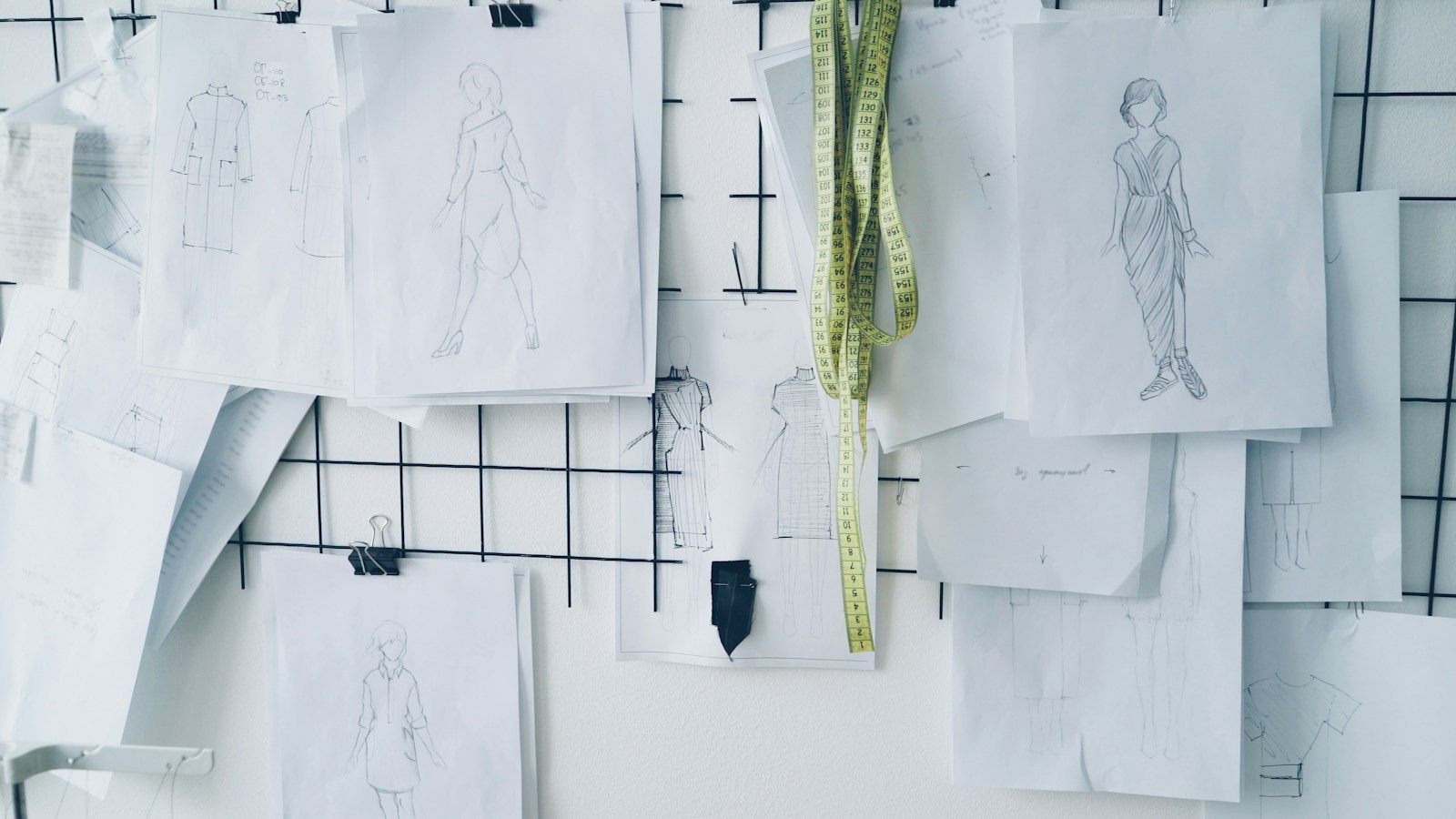 Croquis de moda presos em um painel aramado