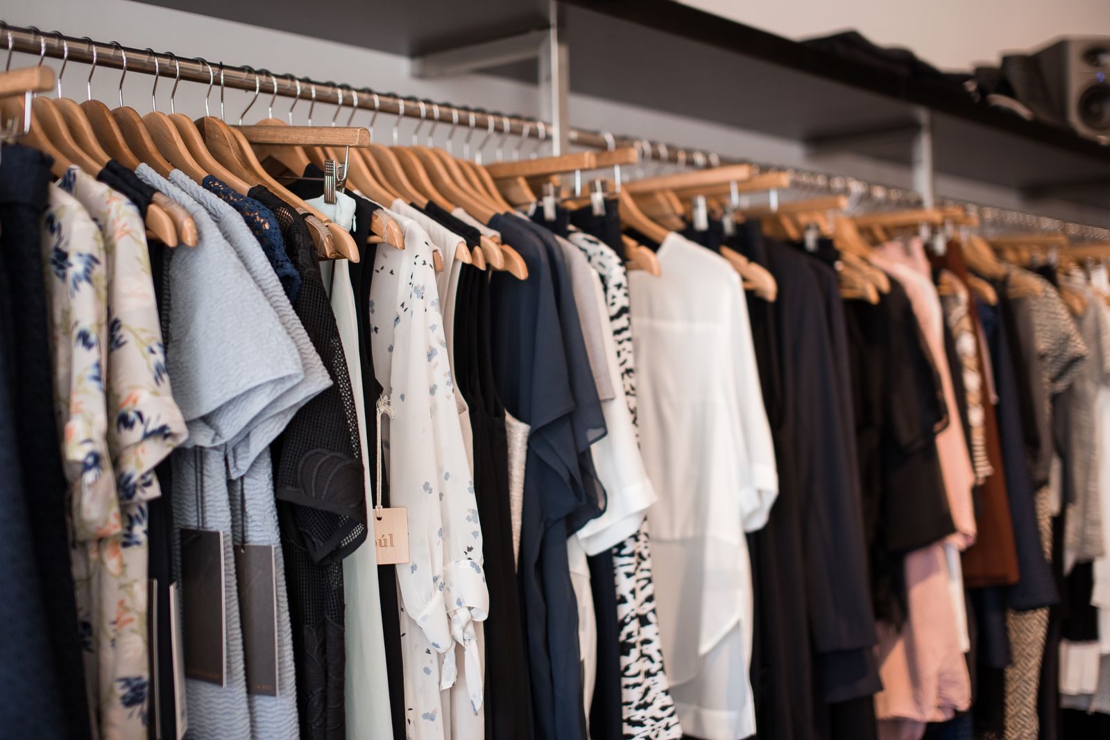 Roupas coloridas em cabides de madeira em uma boutique moderna