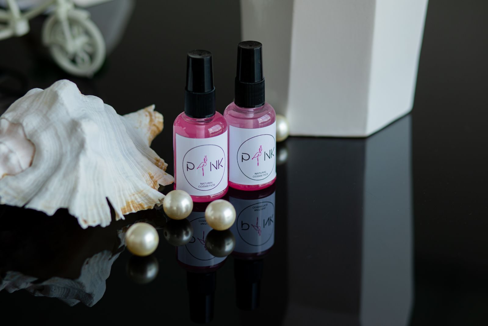 Natureza-morta com frascos de cosméticos rosa, concha branca e pérolas