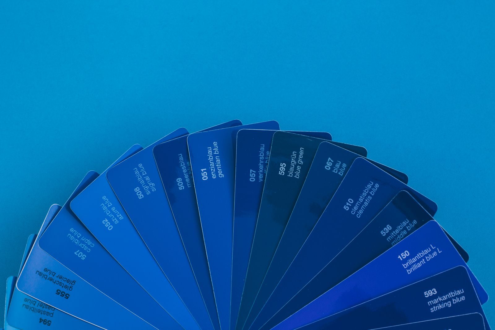 Leque de amostras em tons vibrantes de azul sobre fundo azul intenso