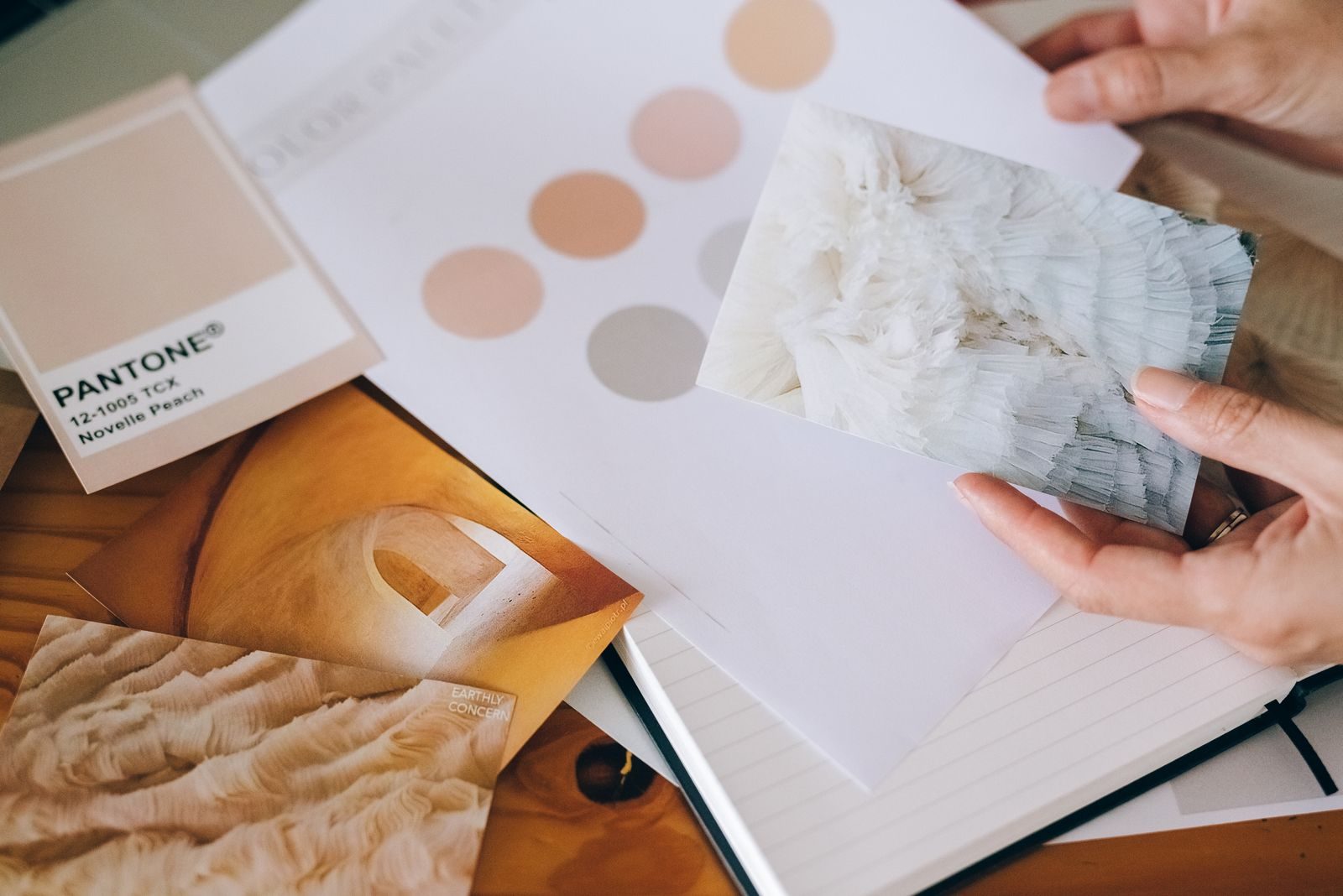 Mãos segurando amostras Pantone e cartões texturizados para inspiração de design