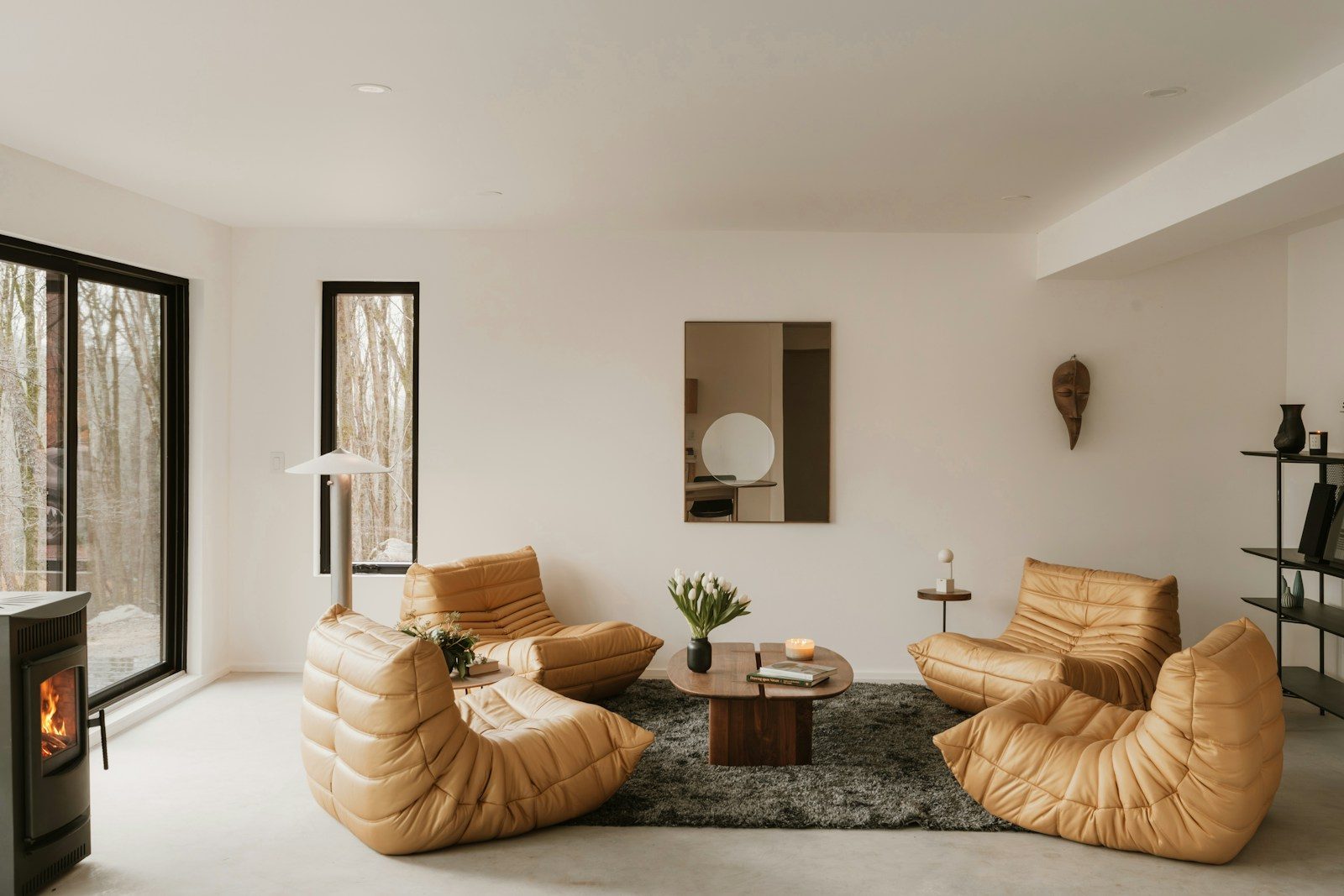 Sala de estar moderna com poltronas de couro caramelo e lareira