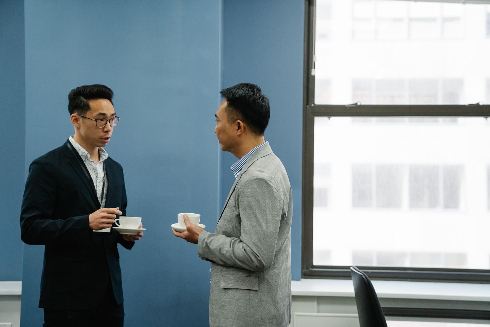 Dois profissionais conversando de forma amigável durante um café no escritório
