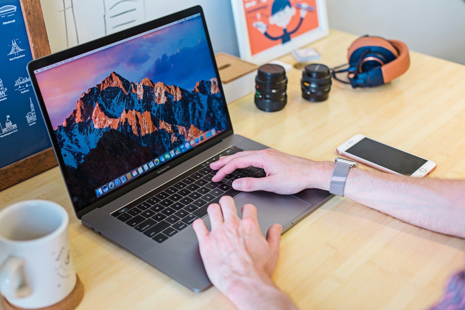MacBook Pro ligado ao lado de uma caneca de cerâmica branca