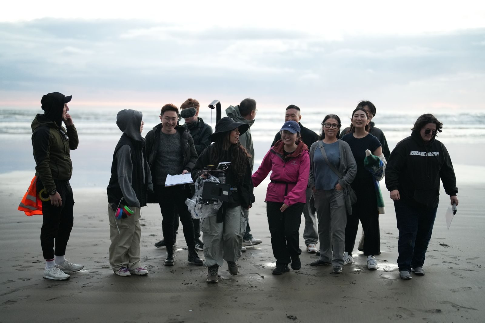 Grupo diverso de cineastas gravando cenas em uma praia de paisagem bonita