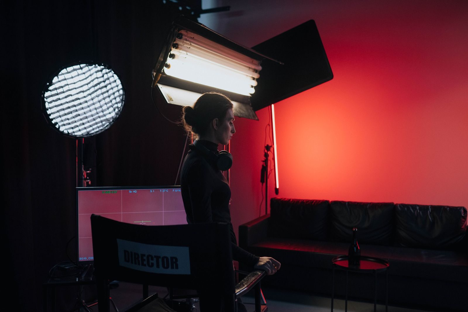 Diretor em um estúdio com iluminação e equipamentos, criando uma atmosfera cinematográfica