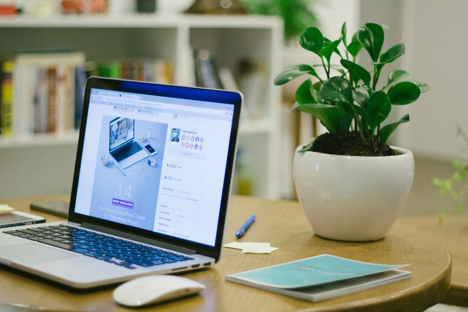 Espaço de trabalho moderno com notebook e vaso de planta em uma mesa organizada