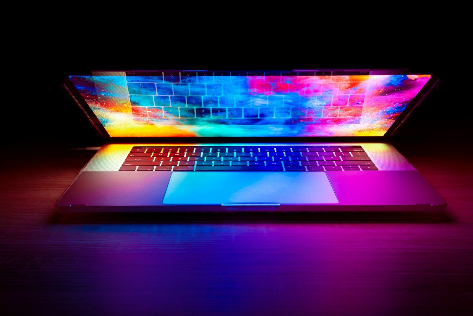 Notebook com tela colorida e vibrante brilhando em uma mesa de madeira escura