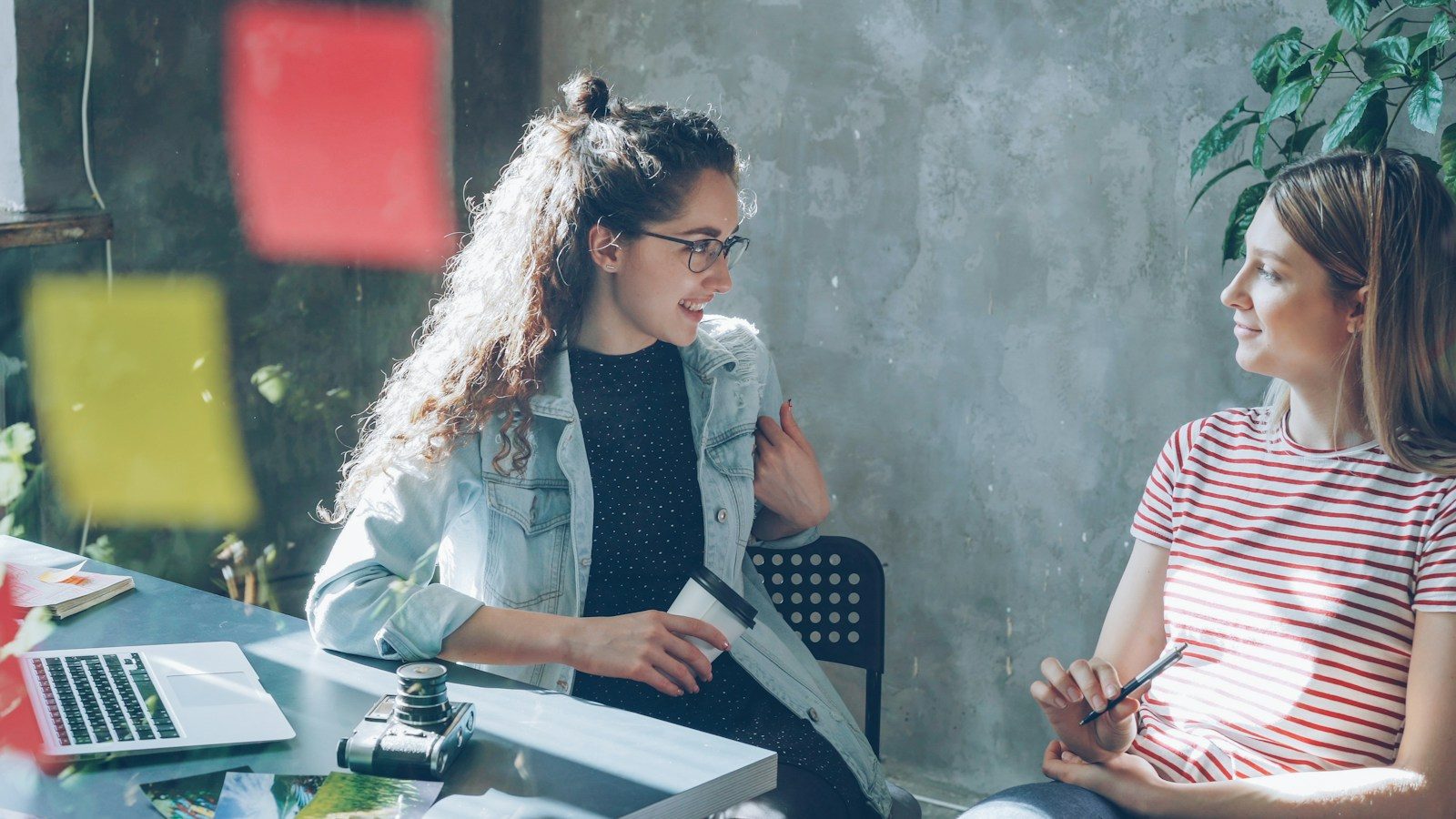 Duas mulheres conversando em um escritório claro