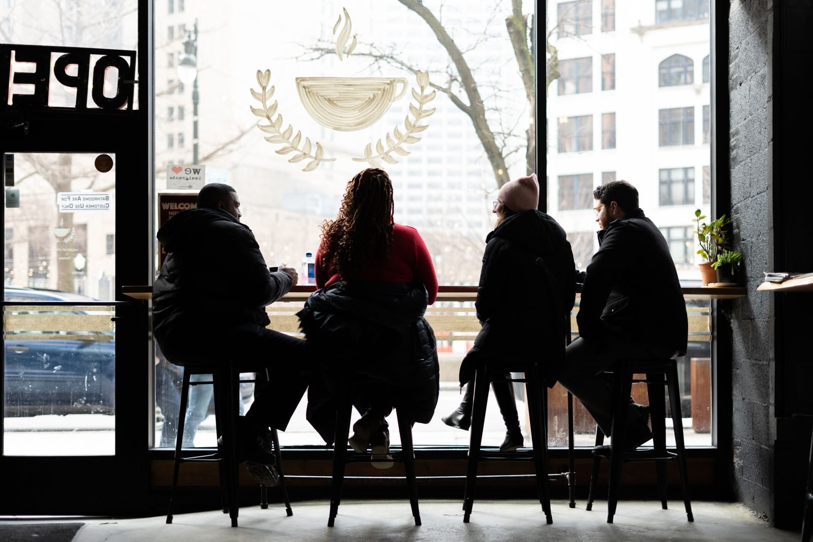 Amigos aproveitando uma tarde aconchegante em um café de Detroit, sentados junto à janela