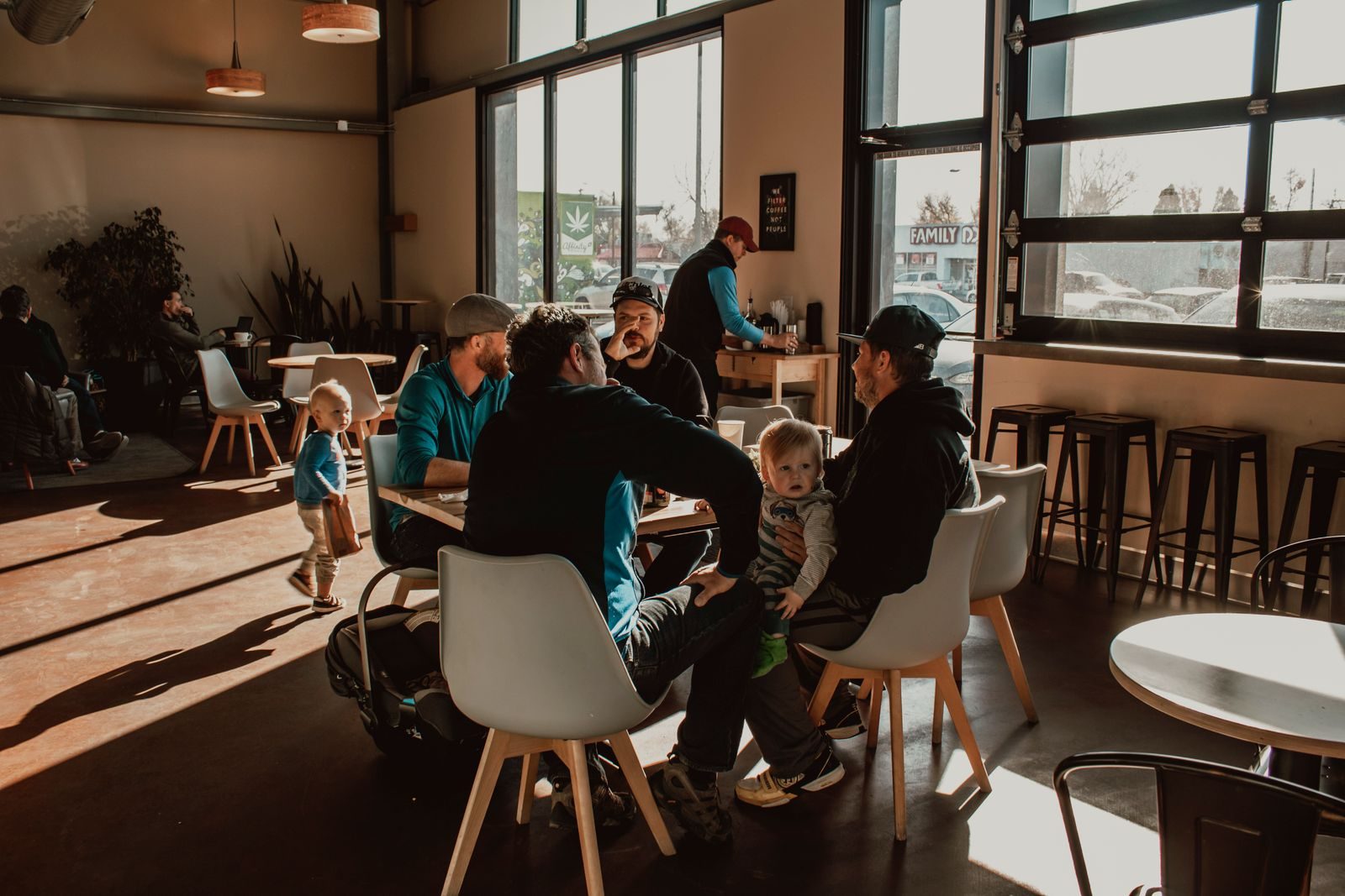 Grupo de amigos aproveitando uma tarde ensolarada em um café moderno