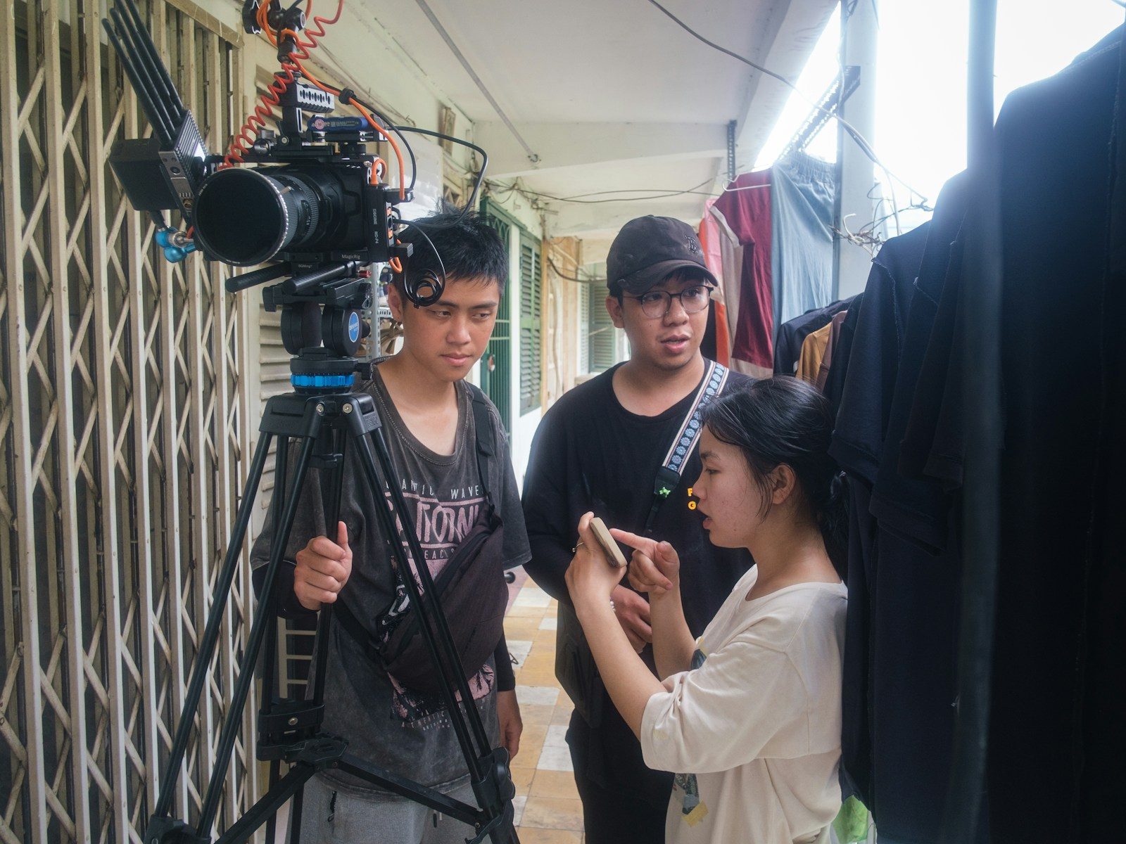 Três pessoas trabalhando com uma câmera em um set de filmagem